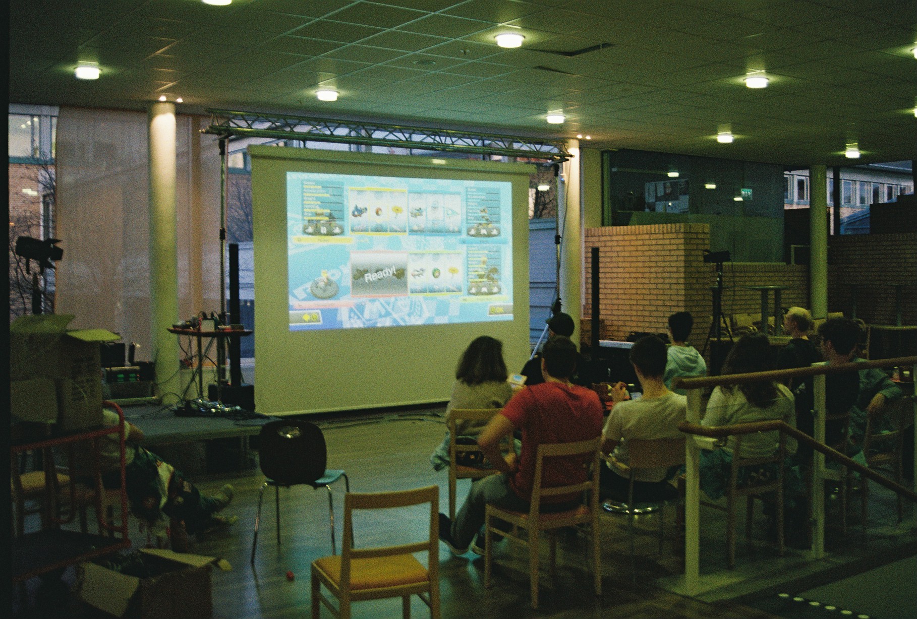 Group of people playing Mario Kart on a projector screen